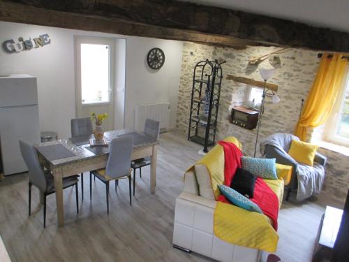 a living room with a table and a dining room at La Ferme de la Chapelle-Saint-Jean in Beynat