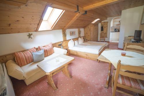 een kamer met een bank, een bed en een tafel bij Ferienhaus Tannenblick in Leutasch