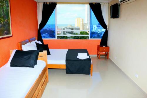 - une chambre avec 2 lits et une grande fenêtre dans l'établissement Apartment in Cartagena in front of the sea 1C11, à Carthagène des Indes