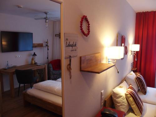 a room with a bedroom with a bed and a desk at Hotel Restaurant Grüner Baum und Altes Tor in Bad Waldsee