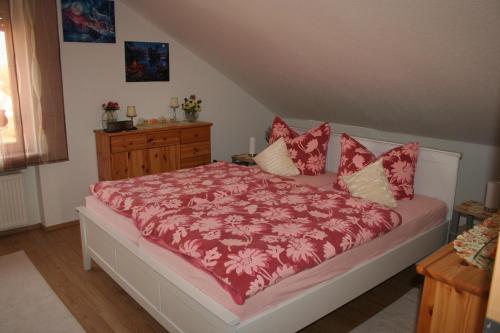 Schlafzimmer mit einem Bett mit einer roten Bettdecke in der Unterkunft Ferienwohnungen Alt in Naumburg