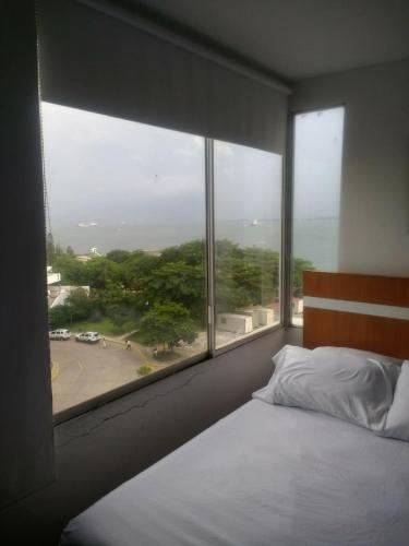 ein Schlafzimmer mit einem Bett und einem großen Fenster in der Unterkunft Apartment in Cartagena Ocean Front 1C5 in Cartagena de Indias