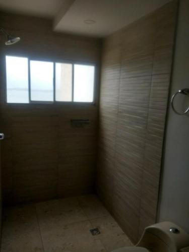 ein Bad mit Dusche und eine Tür mit Fenster in der Unterkunft Apartment in Cartagena Ocean Front 1C5 in Cartagena de Indias