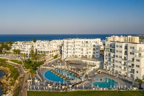 an aerial view of a resort with a pool and buildings at King Jason Protaras - Designed for Adults by Louis Hotels in Protaras