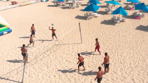 a group of men playing a game of volleyball on the beach at Mirage Hotel Sidi Abd El Rahman in El Alamein