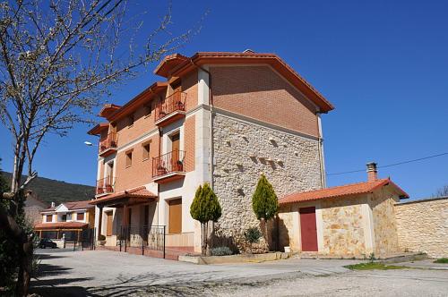 um grande edifício de tijolos com uma varanda numa rua em hotel rural anamari em Cigüenza