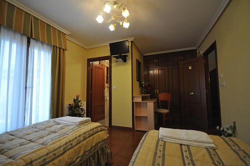 a hotel room with two beds and a bathroom at hotel rural anamari in Cigüenza