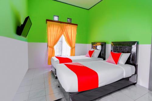 En eller flere senge i et værelse på OYO 2903 Putri Residence Syariah