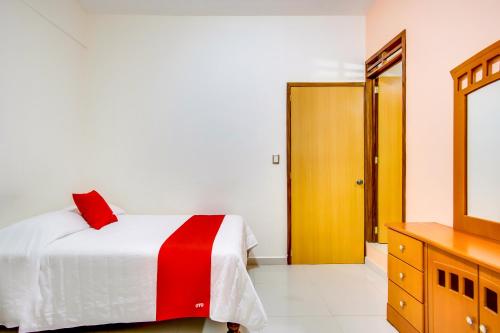 a bedroom with a bed and a dresser and a mirror at Hotel La Estancia in Colima