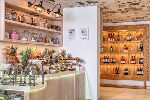 a kitchen with a counter with bottles of wine at King Jason Protaras - Designed for Adults by Louis Hotels in Protaras