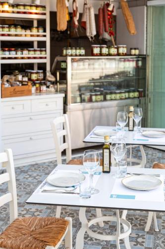 two tables with wine glasses on them in a kitchen at King Jason Protaras - Designed for Adults by Louis Hotels in Protaras