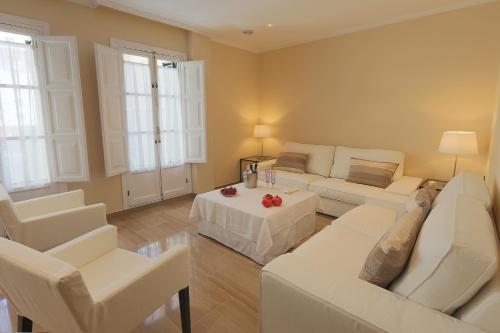 sala de estar con muebles blancos y mesa en Epicenter, en Sevilla