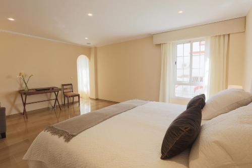 1 dormitorio con 1 cama blanca grande y ventana en Epicenter, en Sevilla