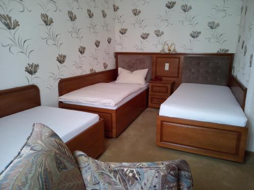 um quarto com 2 camas individuais e um sofá em Hotel Stadt Lügde em Lügde