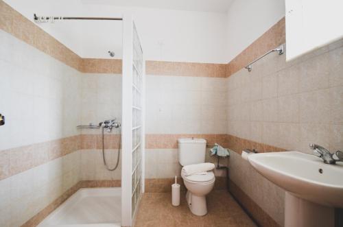 un baño con inodoro y lavabo en Coliseum Studios & Apartments, en Pefki