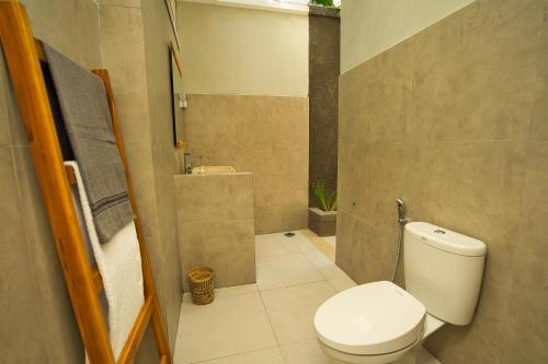 a small bathroom with a toilet and a sink at Dalai Home in Kuta Lombok