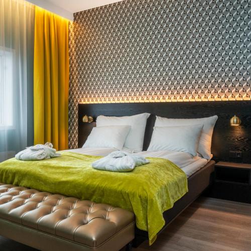 a bedroom with a large bed with a green blanket at Thon Hotel Oslo Airport in Gardermoen
