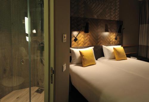 a bedroom with a large bed with yellow pillows at Ibis Casa Voyageurs in Casablanca
