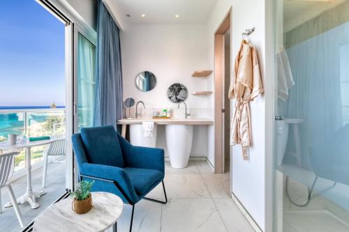 a bathroom with a blue chair and a sink at King Jason Protaras - Designed for Adults by Louis Hotels in Protaras