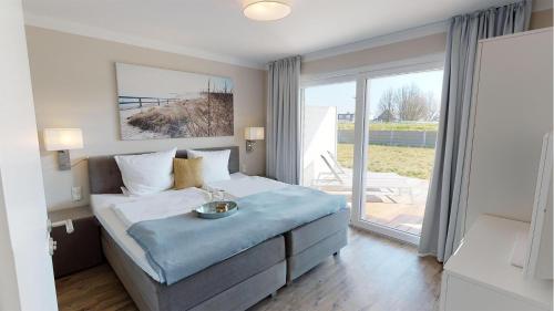 a bedroom with a bed and a large window at Beach'n'Sea Wohnung 2 in Grömitz