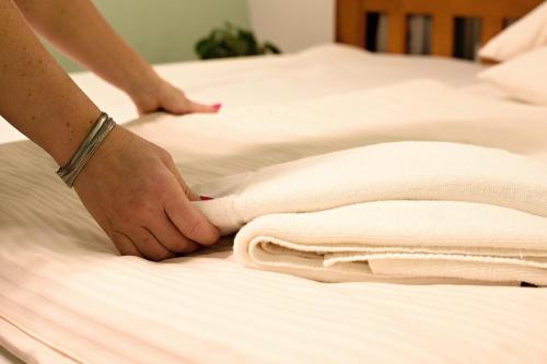 a person is making towels on a bed at Apart Hotel Jablonec in Jablonec nad Nisou