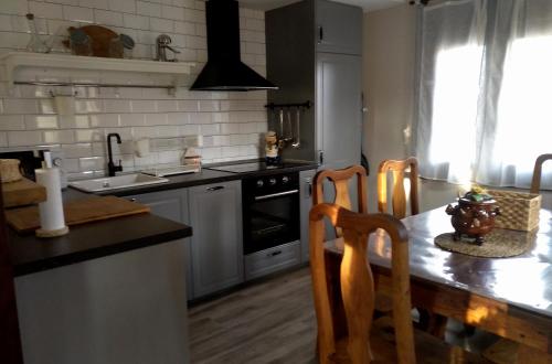 a kitchen with a table and a stove top oven at La Casita Del Abuelo in Villalmanzo