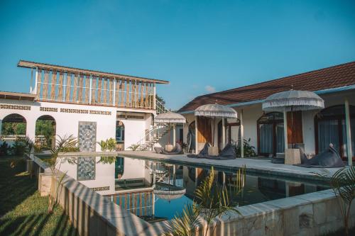 a house with a swimming pool in front of it at Suku Lifestyle Hotel & Villas in Selong Belanak