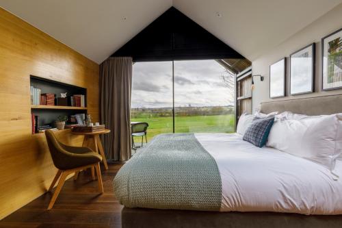 a bedroom with a bed and a large window at Feldon Valley in Lower Brailes