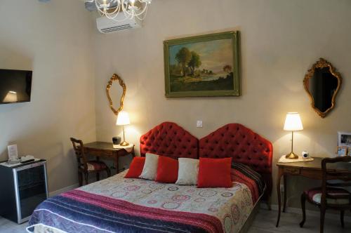 a bedroom with a bed with a red head board at Le Manoir du Raveyron in Vallon-Pont-dʼArc