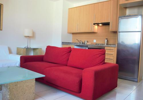 un sofá rojo en la sala de estar con cocina en Vista Torre, en Santa Cruz de Tenerife