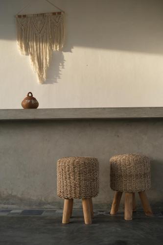 two wicker chairs sitting in front of a shelf at Suku Lifestyle Hotel in Selong Belanak