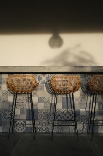 three bar stools sitting in front of a counter at Suku Lifestyle Hotel & Villas in Selong Belanak