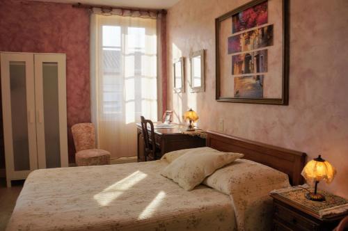 ヴァロン・ポン・ダルクにあるMaison du Manoirのベッドルーム1室(ベッド1台、デスク、窓付)