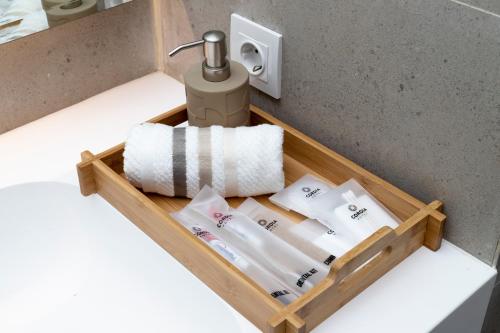 a wooden tray with towels and a faucet in a bathroom at Cordia Hotel Yogyakarta - Hotel Dalam Bandara in Glagah