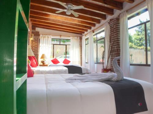 a bedroom with two beds and a ceiling fan at Valle Dorado in Valle de Bravo