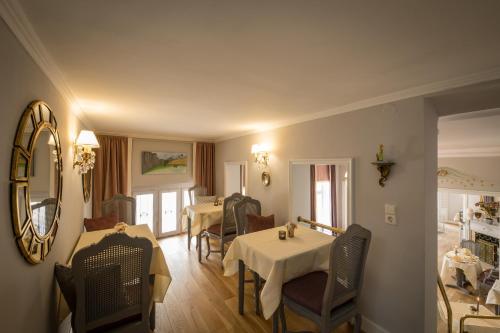 a dining room with two tables and a mirror at Hotel Der Kleine Prinz in Baden-Baden
