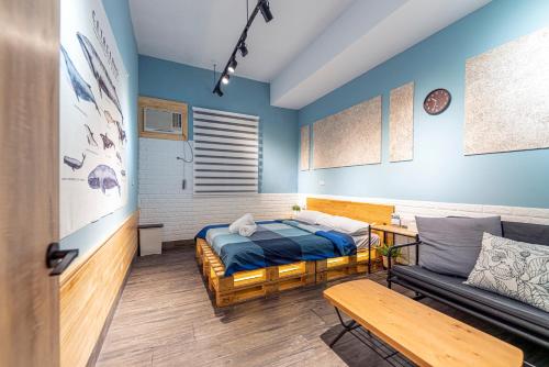ein Schlafzimmer mit einem Bett und einem Sofa in der Unterkunft Ofucos Adventure Hostel in Gongliao