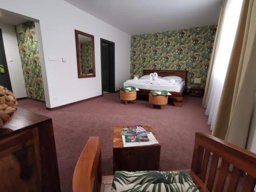 a room with a bed and a table and chairs at Malkia Penzion in Orechová Potôň