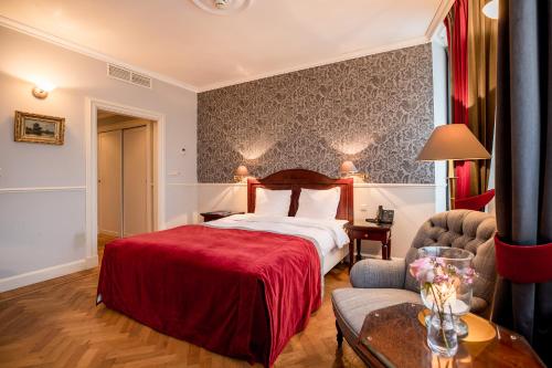 a hotel room with a bed with a red blanket at Kasteel de Wittenburg in Wassenaar