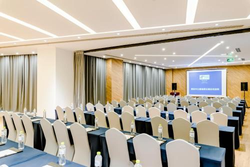 a conference room with chairs and a projection screen at Holiday Inn Express Taian City Center by IHG in Tai'an