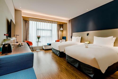 a hotel room with two beds and a couch at Holiday Inn Express Taian City Center by IHG in Tai'an
