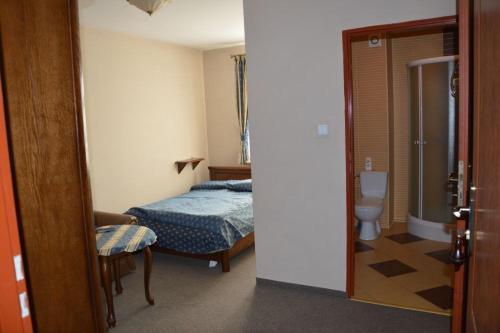 a bedroom with a bed and a bathroom with a toilet at Jurajska Perła in Pątnów