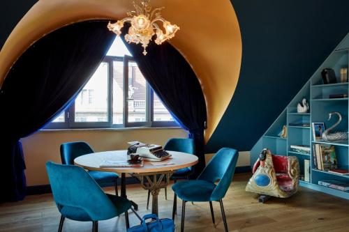 a dining room with a table and blue chairs at 25hours Hotel The Royal Bavarian in Munich