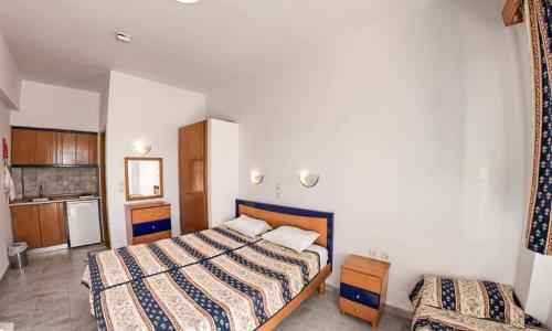 a hotel room with two beds and a kitchen at Coralli Apartments in Pefki Rhodes