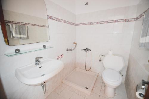 ロードスにあるCoralli Apartmentsの白いバスルーム(トイレ、シンク付)