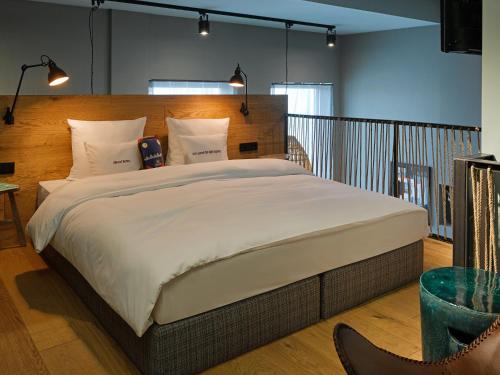 a bedroom with a large bed with a wooden headboard at 25hours Hotel The Trip in Frankfurt