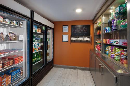 a grocery store aisle with an orange wall at Holiday Inn Express Hotel & Suites Uptown Fredericton by IHG in Fredericton