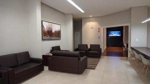 a living room with couches and chairs and a table at JB Palace Hotel in Divinópolis