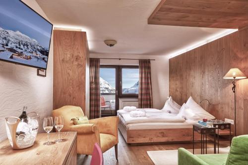 a hotel room with a bed and a tv at Hotel Goldener Berg in Lech am Arlberg