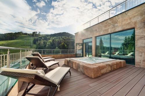 a master bedroom with a large bed on a wooden deck at Hotel Pegaz in Krynica Zdrój